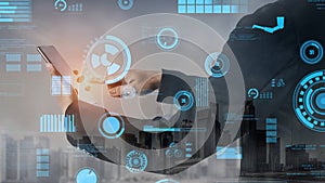 Business professional using smartphone to interact with futuristic data visualization technology in a modern urban