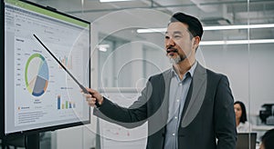 Asian Businessman Presenting Data on Digital Screen in Modern Office