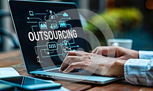 Business Professional Using Laptop to Strategize Outsourcing Operations with Virtual Interface