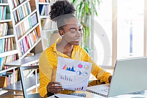 Business professionals. Business woman analyzing data using computer while spending time in the office. Beautiful young grinning