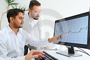 Business professionals. Group of young confident business people analyzing data using computer while spending time in