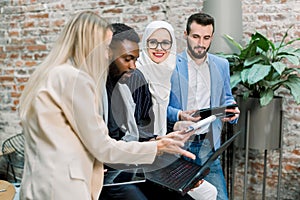 Business professionals. Group of young multiethnic confident business people analyzing data using laptop computer while