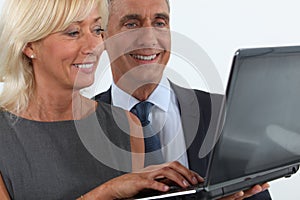 Business professionals looking at a laptop