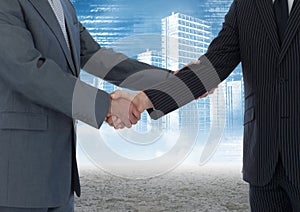 Business professionals shaking hands against cityscape in background