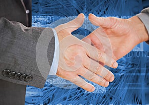 Business professionals shaking hands against coding background