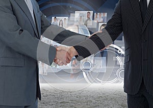 Business professionals shaking hands against technology background