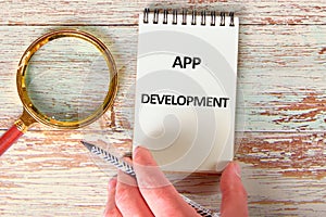 Business, programming, interface, application and network concept. Text APP DEVELOPMENT in a notebook against the