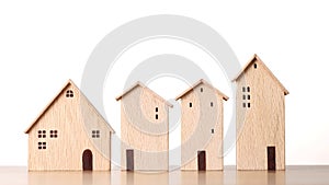 Business property investment concept, model wooden houses on wooden desk on white background studio for financial real estate