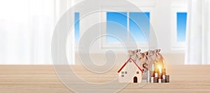 Business property investment model wooden house with money bag and stacking coin on bright interior room background with copy