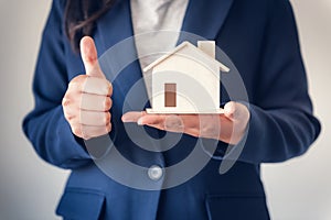 Business Property Selling and Estate Investment Concept, Close-Up Portrait of Business Woman in Suit Showing House Model With