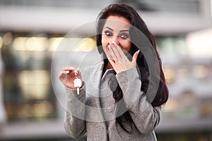 Business, real estate, banking and people concept - smiling business woman with keys over office room or new apartment background