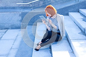 Business redhead woman reading carefully tablet
