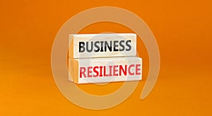 Business resilience symbol. Concept word Business resilience typed on wooden blocks. Beautiful orange table orange background.