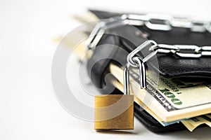 Business safety or financial protection or allow access. Heap of money in chain with open padlock isolated on white