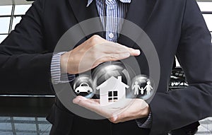 Business salesman hand holding home, car, family