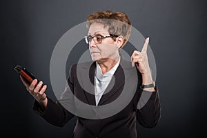 Business senior lady having idea holding smartphone