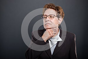 Business senior lady holding neck like hurting