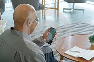 Business senior old elderly Black American man, African person using a smartphone or mobile phone with blank screen space on