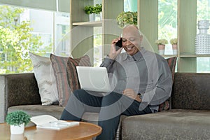 Business senior old elderly Black American man, African person using a smartphone or mobile phone in living room at home in