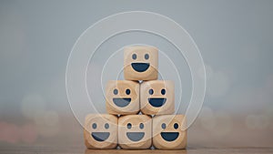 Business service rating, customer satisfaction, or teamwork concept. Smiling face icons on wooden cubes