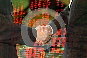 Business shaking hand on finacial graph background.