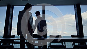 Business silhouettes shaking hands meeting in conference room. Two managers work