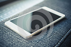 Business Smartphone Lying On The Armrest Of A Couch