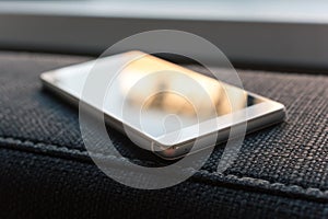 Business Smartphone With Reflection Lying On The Armrest Of A Couch