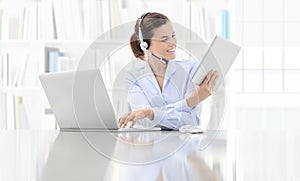 Business smiling woman or a clerk working at her office desk wit