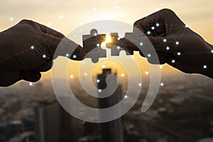 Closeup hand of businessman connecting jigsaw puzzle with sunlight effect photo