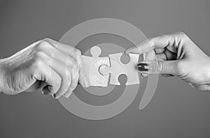 Business solutions, success and strategy concept. Hands connecting puzzle. Hand of the man and hand of woman fold puzzle