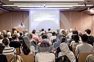 Business speaker giving a talk at business conference event.