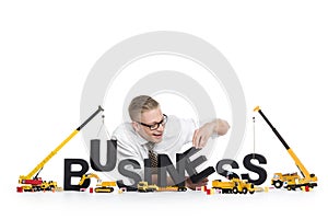 Business start up: Businessman building business-word.