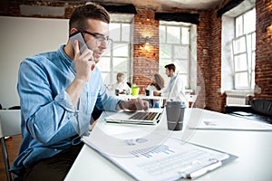 Business, startup and people concept - happy businessman or creative male office worker with computer calling on photo