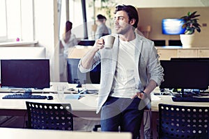 Business, startup and people concept - happy businessman or creative male office worker drinking coffee