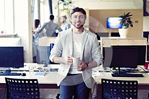 Business, startup and people concept - happy businessman or creative male office worker drinking coffee