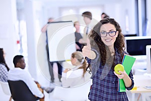 Business, startup and people concept - happy creative team with computer and folder in office