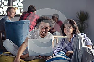 Business, startup, technology and people concept - happy international creative team with laptop and tablet pc computer