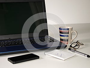 Business still life - laptop, phone, coffee and notebook, on white background