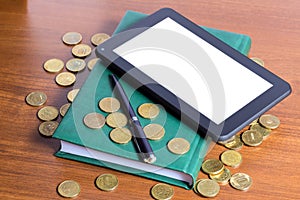 Business still-life - tablet computer, diary, pen and gold coins on desktop businessman