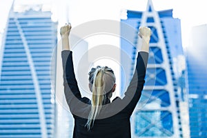 Business success - Celebrating businesswoman overlooking the city center high-rises