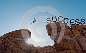 Business success, challenge, achievement and leadership concept. Silhouette a man jumping over precipice to success photo