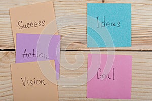 Business and success concept - colorful sticky notes with words success, action, goal, vision, idea