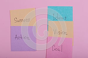 Business and success concept - colorful sticky notes with words success, action, goal, vision, idea