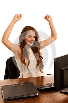 Business success - woman gestures victori with her arms up in th