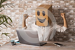 Business and success working with laptop. People with carton box smile on head celebrate and exult in front of a computer. New