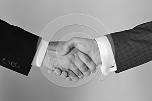 Business succsses. Handshake on light grey background. Businessmen wear smart suits