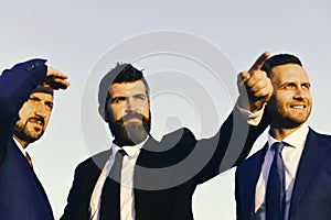 Business succsses. Man with beard and serious face points ahead.