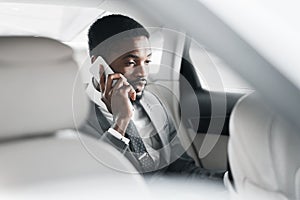 Business talk in car. Businessman talking on mobile phone