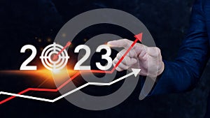 Business target and goal 2023 icon, hand pointing holding 2023 virtual screen and up arrow, Start new year 2023 with a goal plan,